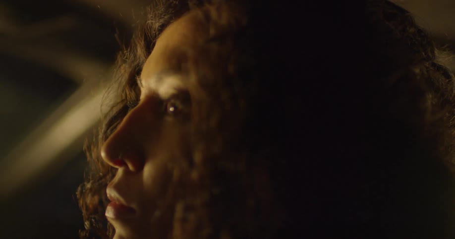 Woman with curly hair turns her head