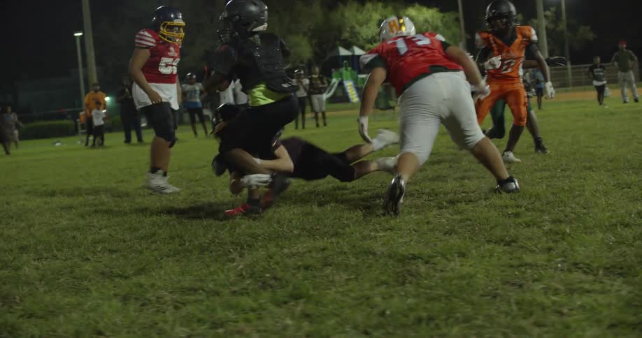 Football players tackle each other during a game