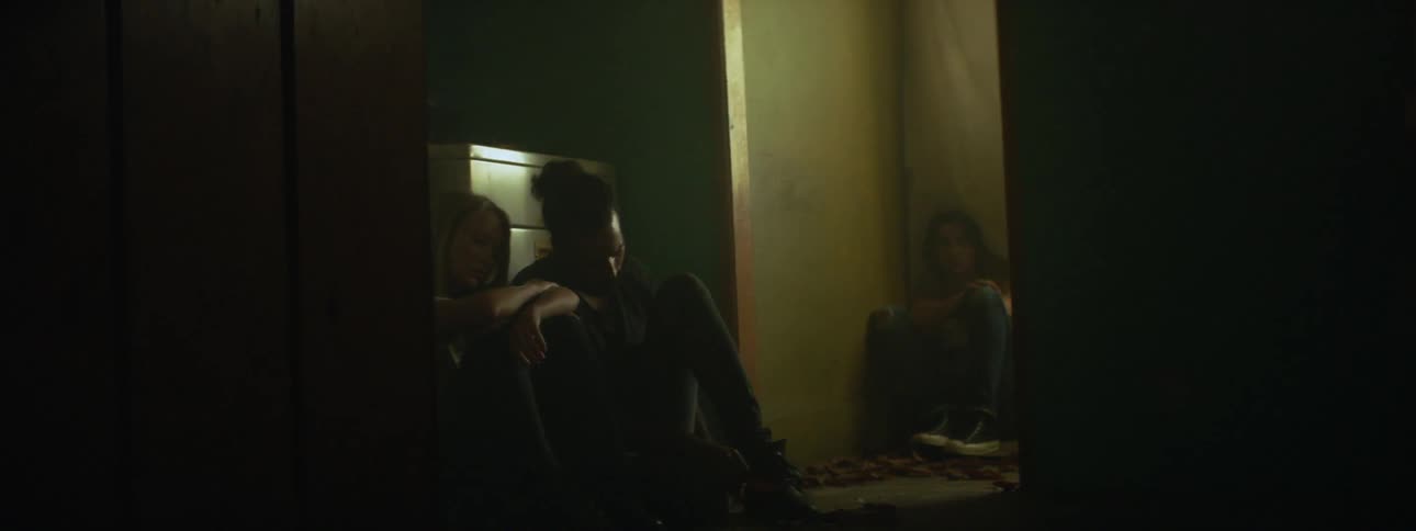 People sit on the floor in a dark laundry room
