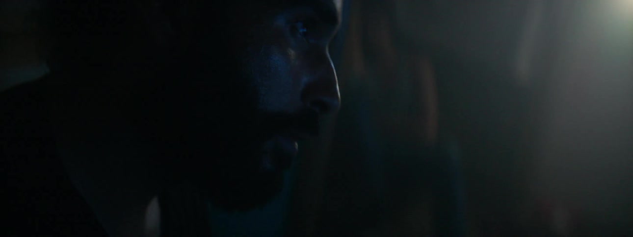 A man sits in a dark room