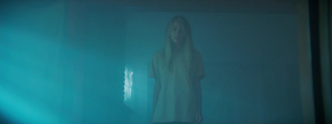 Woman walks slowly towards the rays of sunshine inside a building