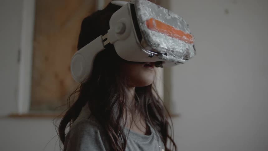 Child is wearing a virtual reality headset in room
