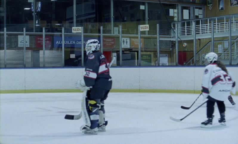 Hockey players are skating and bumping into each other on ice rink
