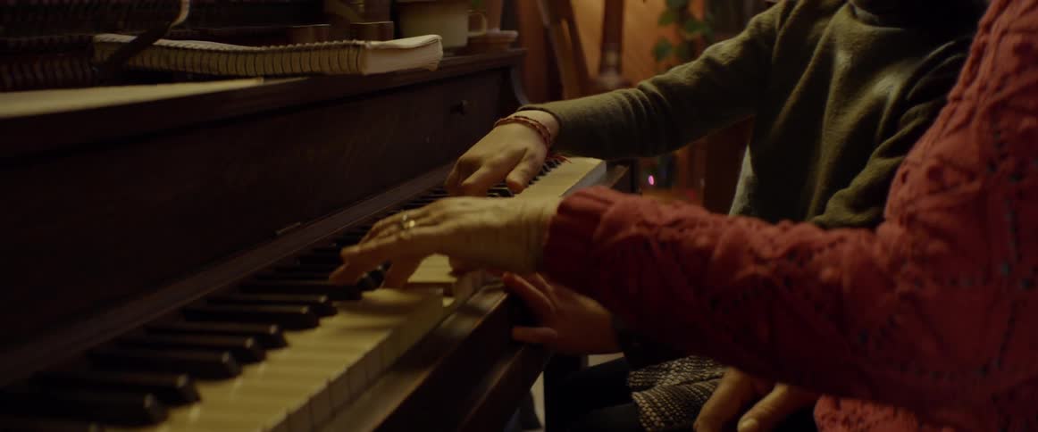 Adult and child play the piano together