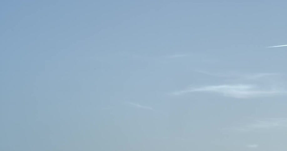 An airplane is leaving a vapor trail is it flies in the sky on a sunny day