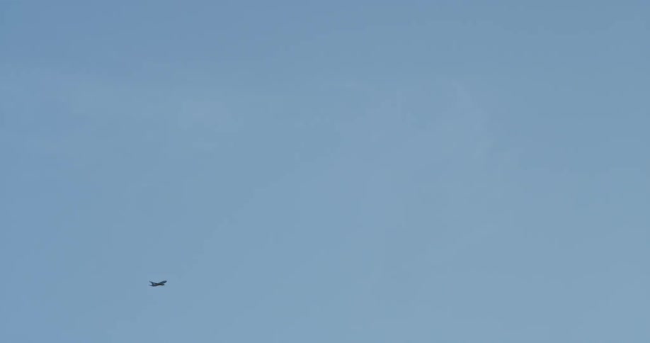 An airplane flies in a clear sky