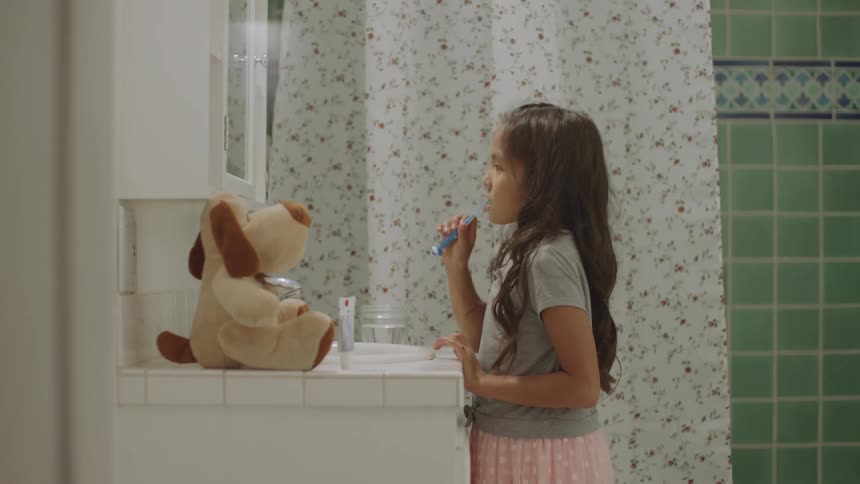 A young girl brushes her teeth