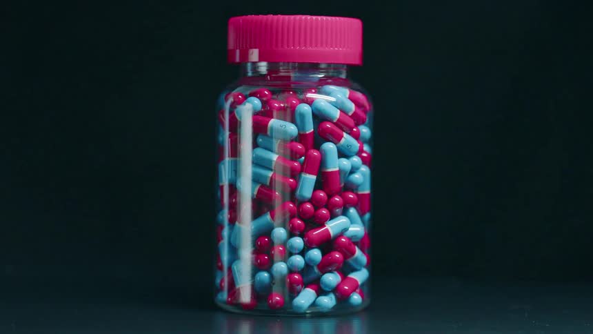 Light is moving across a bottle filled with pills