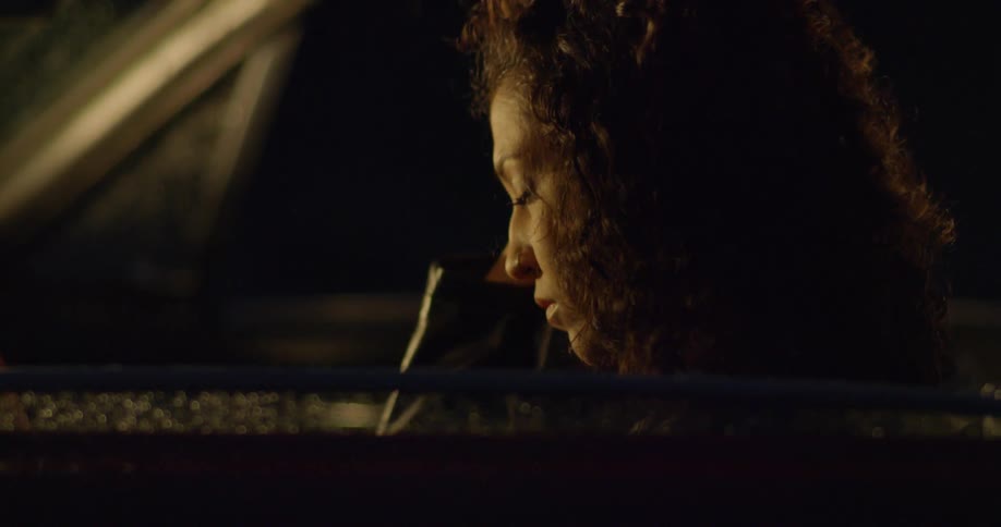 A woman drives a car at night