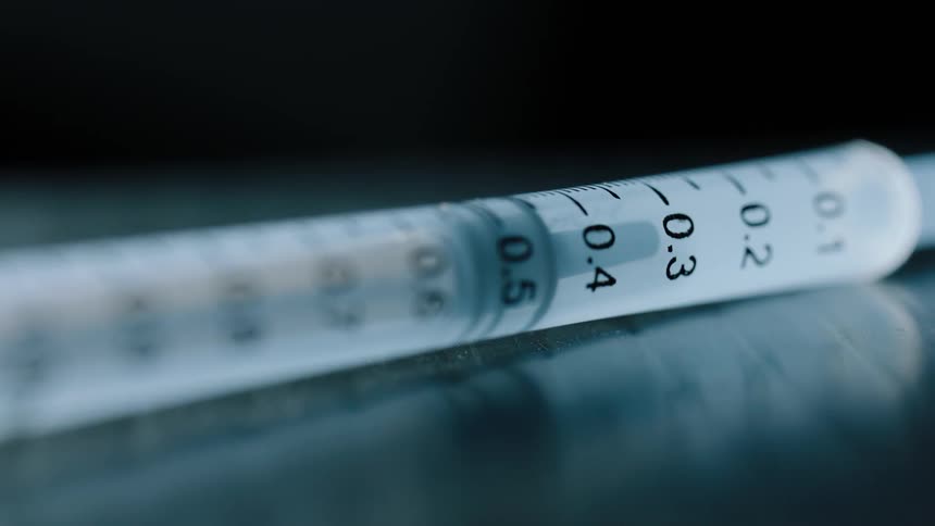 A syringe with numbers printed on it on a table