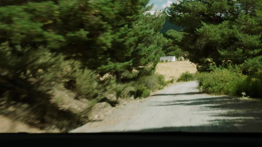 A vehicle drives on a rural road