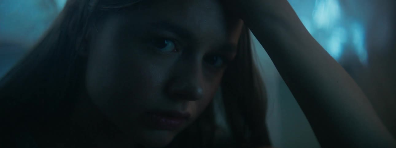 A light shines onto a girl's face at night
