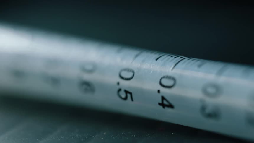 Light reflects off of a syringe tube