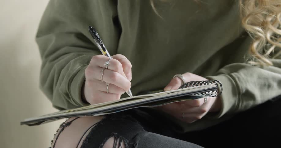 Artist Student is writing in a notebook