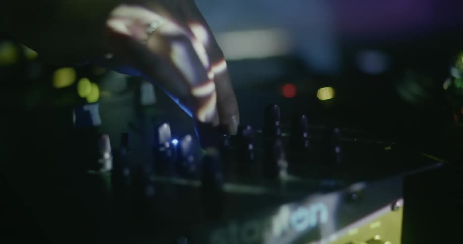 A woman turns knobs on a control board