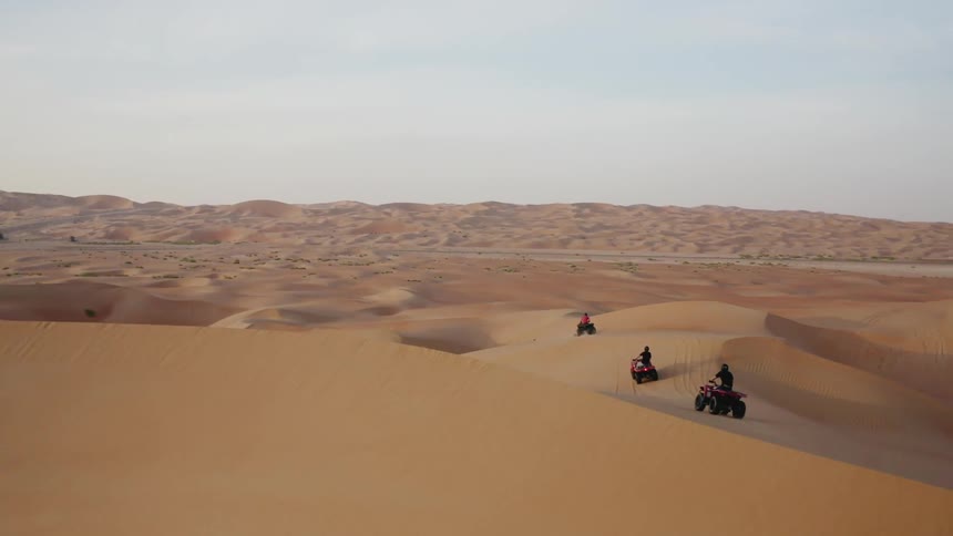 Four wheelers are driven over sand dunes