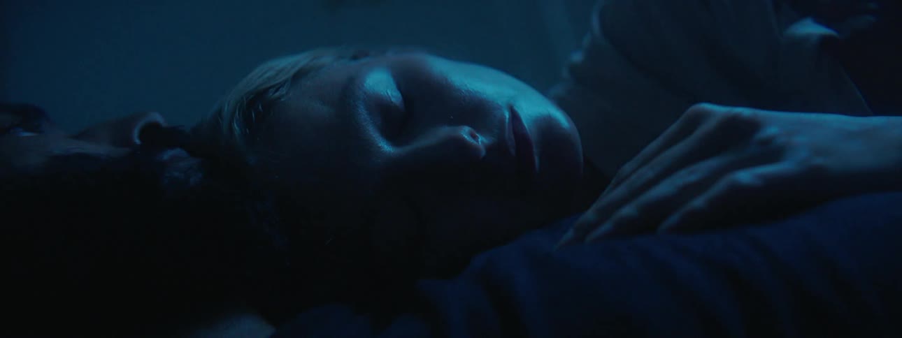 Lights flash around a woman trying to sleep