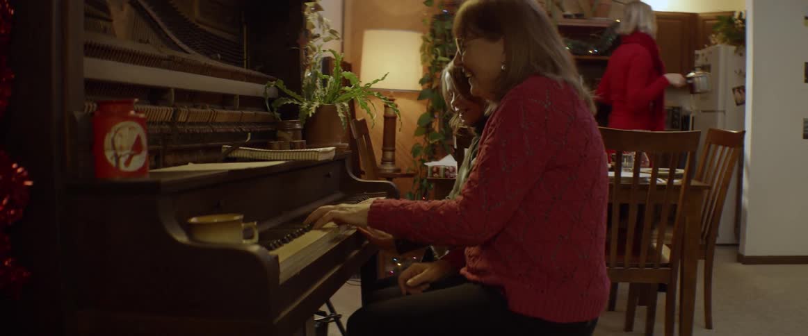 A woman and child play piano