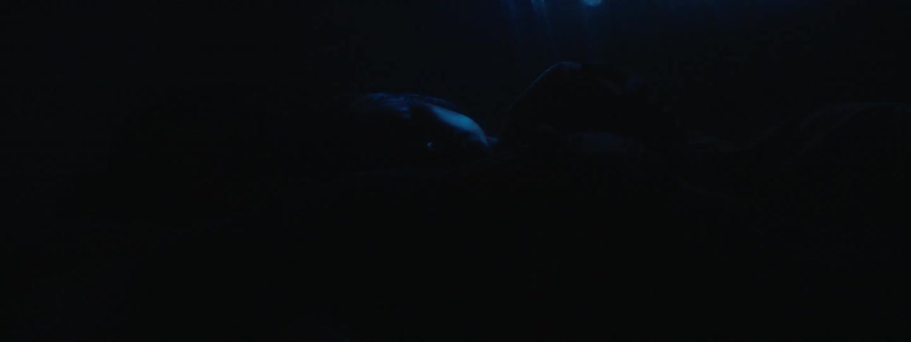 The two people are lying in each other's arms in bed
