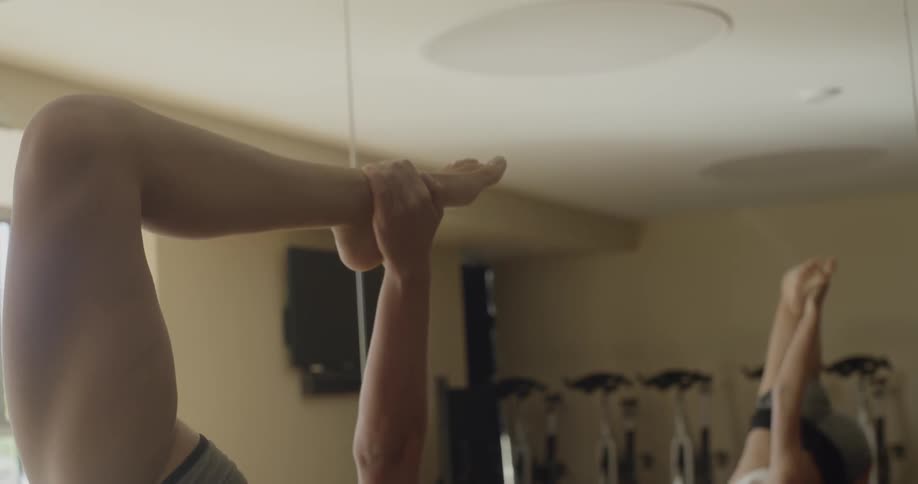 A woman does yoga in a fitness studio