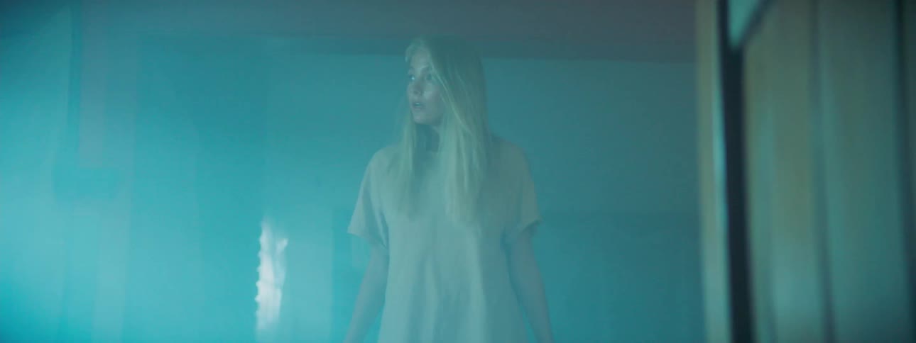 Woman stands in a dim room