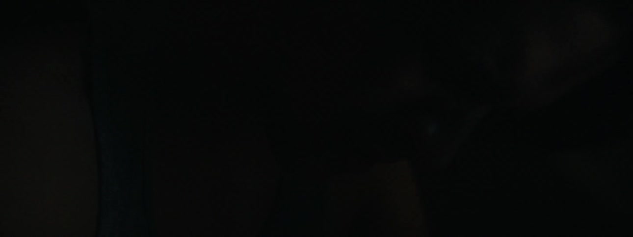 A man is looking down in the dark room