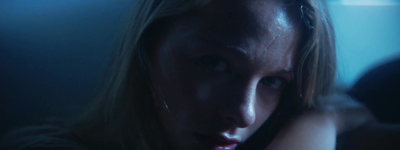 A light shines on a woman's face then fades