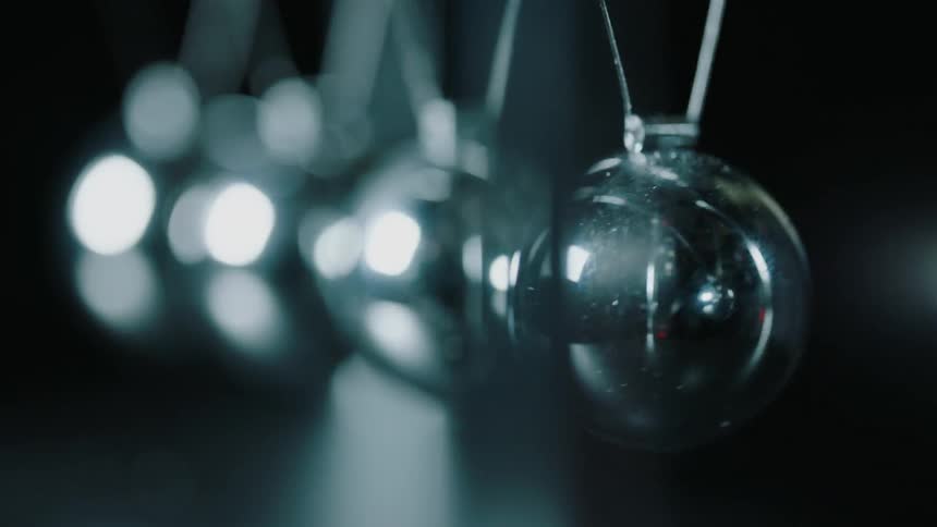 Metal balls in a newton's cradle swing and hit