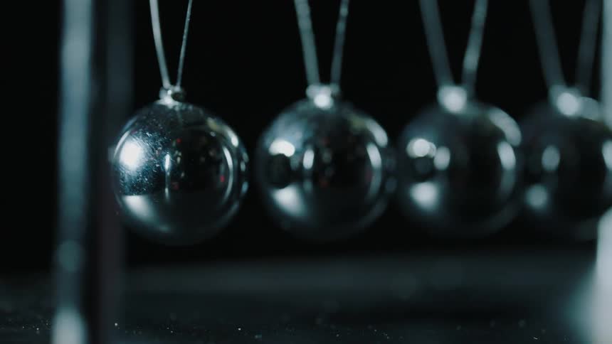 Metal balls hit each other and swing back and forth
