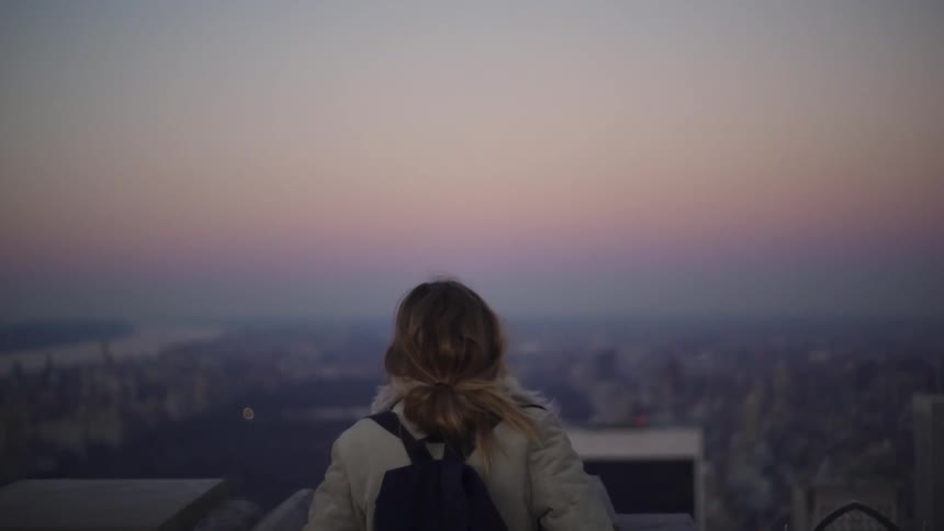 A woman is looking out over the city