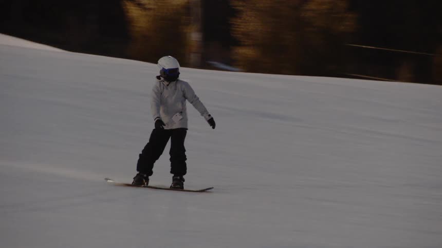A snowboarder glides down a mountainside