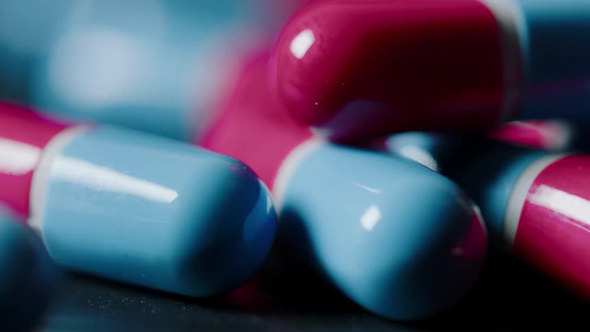 Light reflects off of an assortment of red and blue capsules