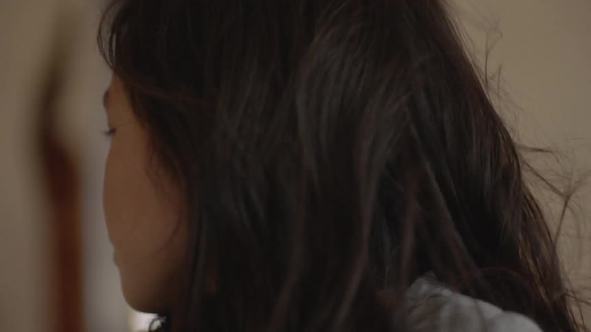 Child looks up as the wind blows her hair