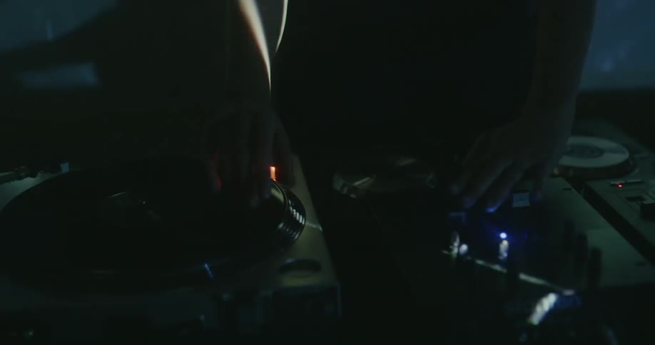 A dj works the turntable as lights flash