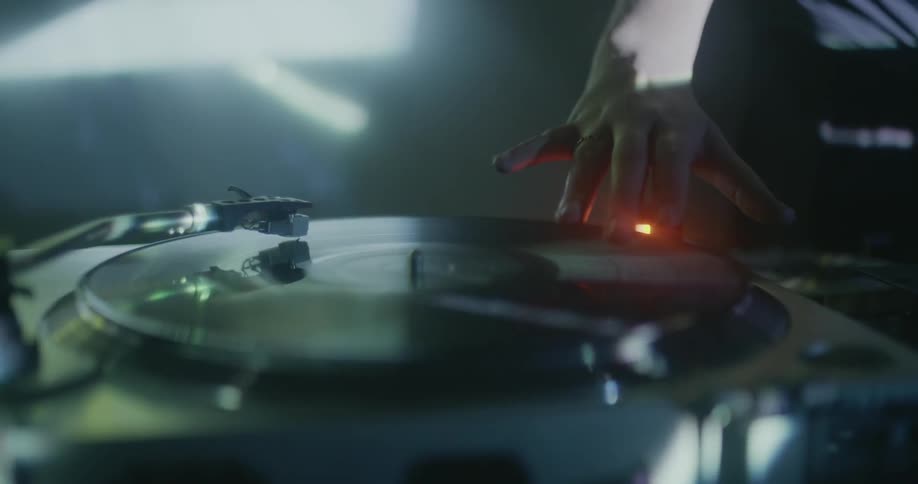 A dj skims her fingers on a turntable