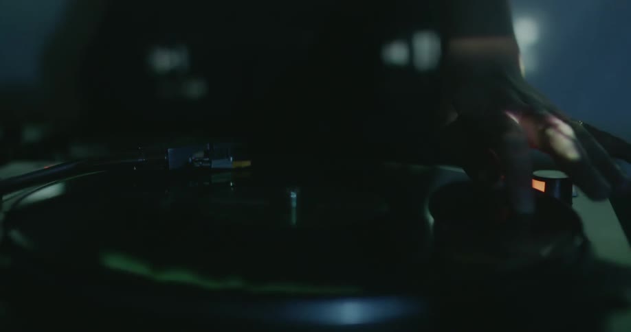 Dj is spinning a record as lights flash