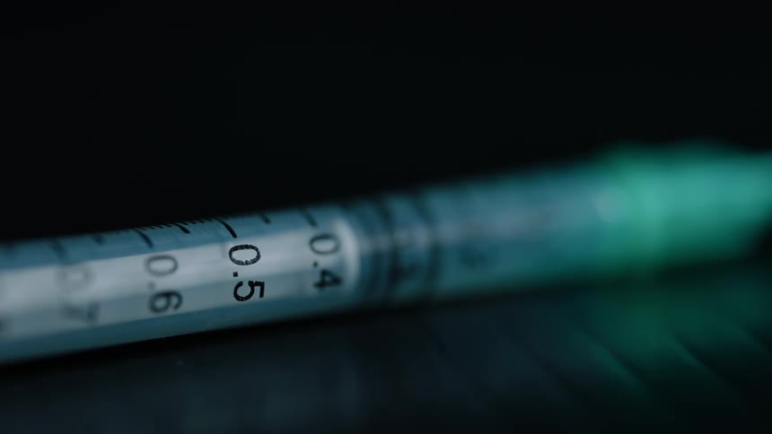 A syringe sits on a table