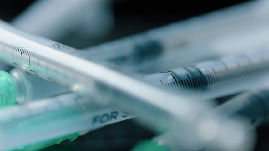 Pile of syringes with dashes and numbers on them