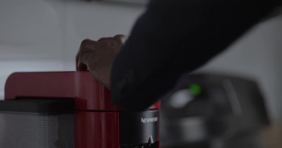A person brews a cup of coffee