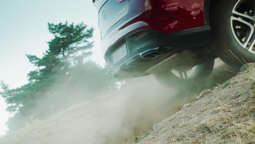 An suv climbs up a sloped dirt trail