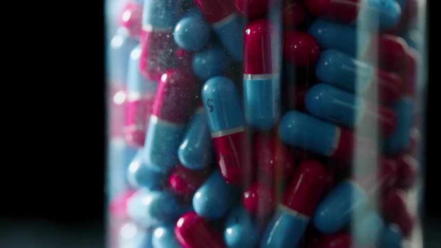Red and blue pills in a jar