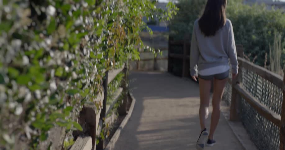 Woman walks on a small fenced path
