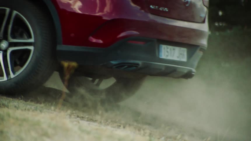 A car drives over dirt and grass