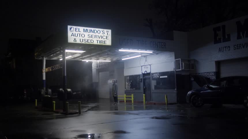 A man stands outside a gas station