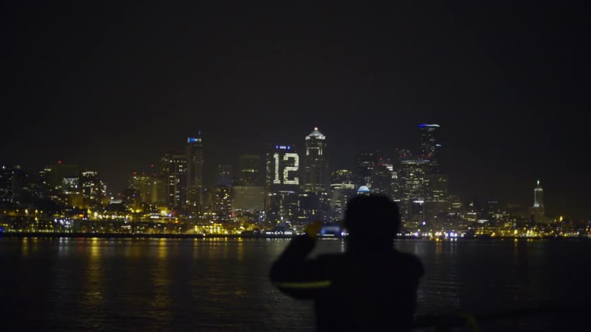 A man looks out onto a city at night