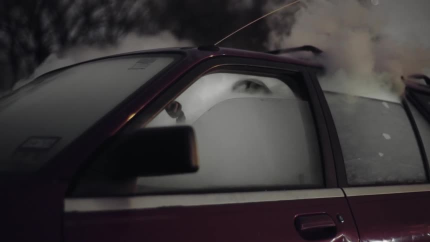 Vehicle with windows partially open and smoke coming out heavily