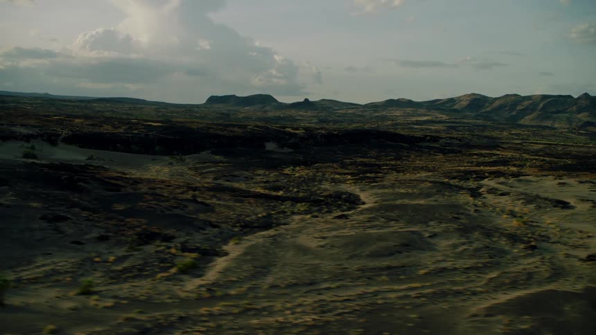 Dirt and shrubs cover the hilly landscape