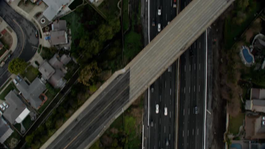 Traffic is flowing on a freeway in an urban area during daylight