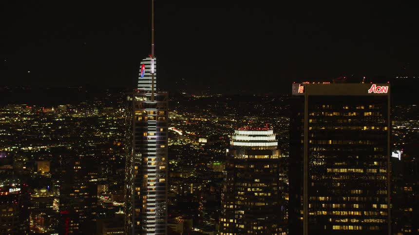 Large city with skyscrapers lit up at night; Los Angeles
