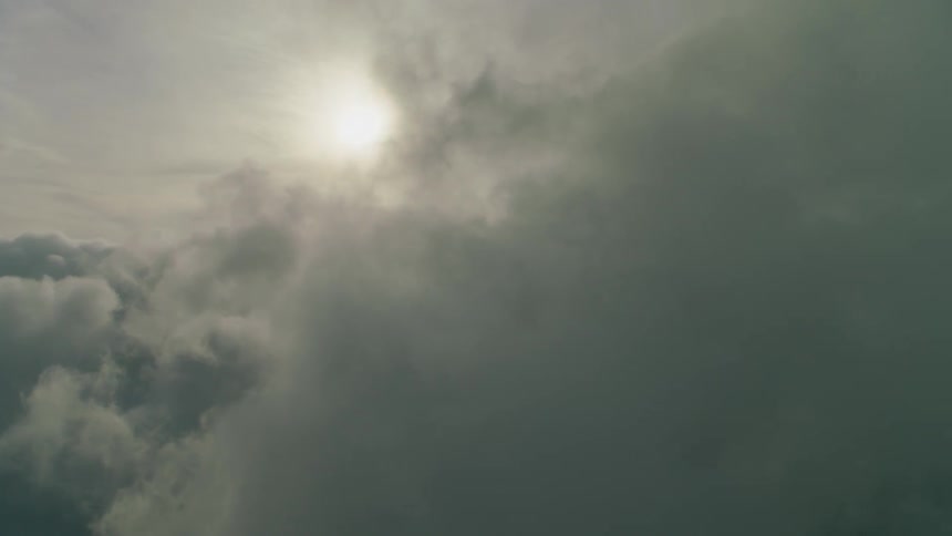 The sun shines through clouds in the sky